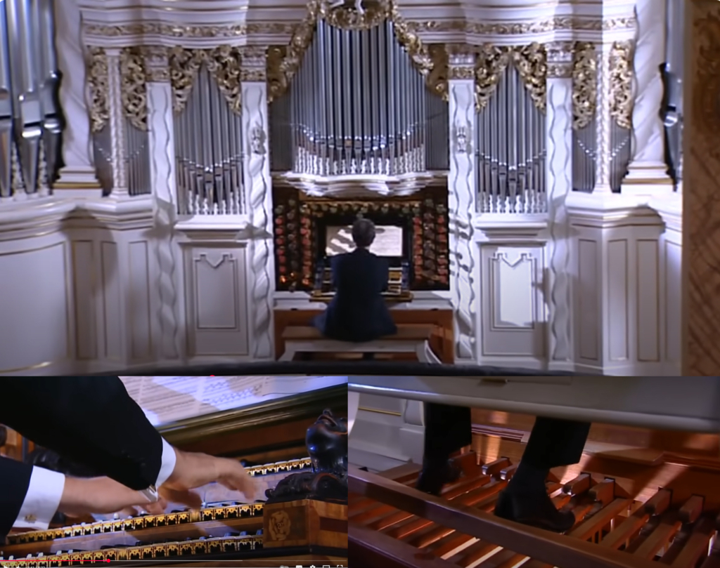 Performance of Bach’s Toccata and Fugue BWV 565 on the Trost organ, showing hands on multiple manuals and feet on the pedalboard.